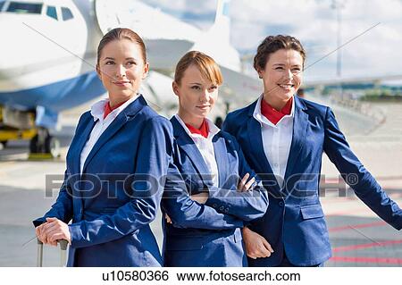 Photo of three confident flight attendants standing against airplane in airport View Large Photo Image Stock Photograph - Photo of three confident flight attendants standing against airplane in airport. Fotosearch