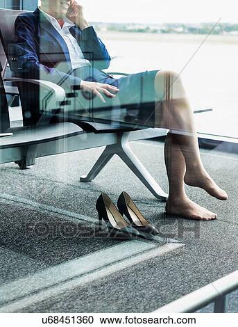 Photo of young attractive airport staff sitting while talking on smartphone View Large Photo Image Stock Image - Photo of young attractive airport staff sitting while talking on smartphone . Fotosearch
