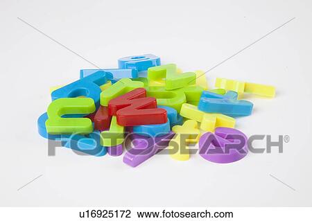 Stock Image - Pile of colorful alphabet magnets over white background. Fotosearch