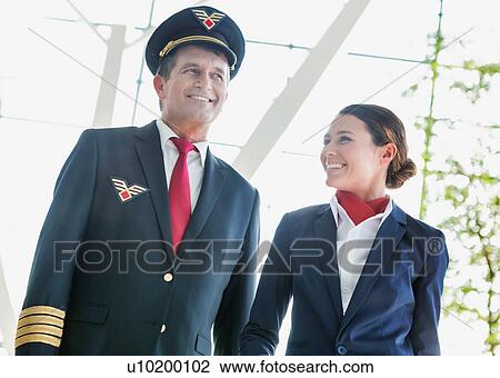 Pilot with flight attendants walking in the airport View Large Photo Image Stock Image - Pilot with flight attendants walking in the airport. Fotosearch