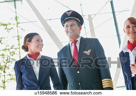 Stock Photograph - Pilot with flight attendants walking in the airport. Fotosearch