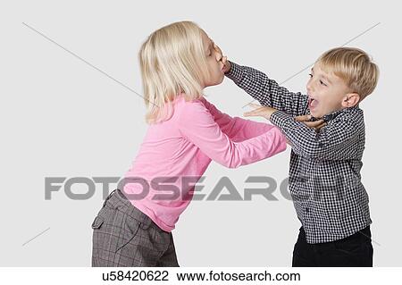 Stock Image - Playful young boy and girl over white background. Fotosearch