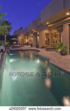 Stock Photo - Pool with house exterior at dusk. Fotosearch