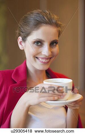 Stock Photo - Portrait of a beautiful young woman holding coffee cup. Fotosearch