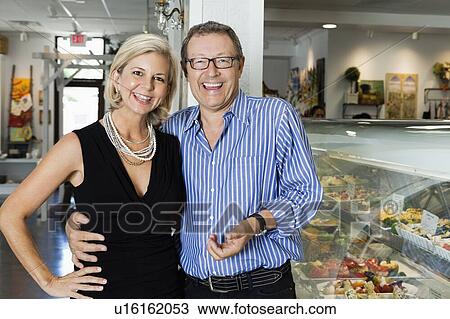 Portrait of a cheerful mature couple at cafeteria View Large Photo Image Stock Image - Portrait of a cheerful mature couple at cafeteria. Fotosearch