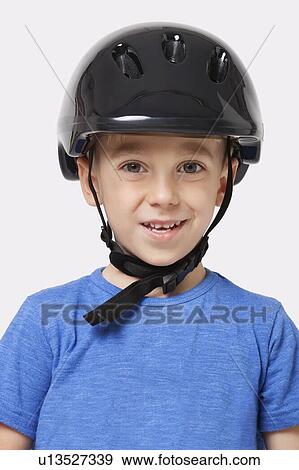 Portrait of a happy little boy wearing bicycle helmet over white background View Large Photo Image Stock Photo - Portrait of a happy little boy wearing bicycle helmet over white background. Fotosearch