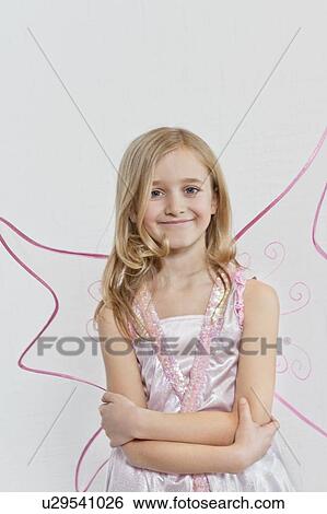 Stock Photograph - Portrait of a happy young girl with arms crossed over colored background. Fotosearch