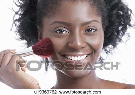 Portrait of a happy young woman applying blush over white background View Large Photo Image Stock Image - Portrait of a happy young woman applying blush over white background. Fotosearch