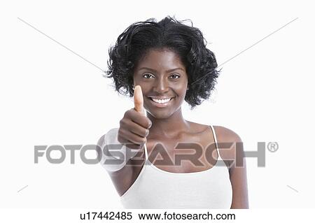Stock Photography - Portrait of a happy young woman gesturing thumbs up over white background. Fotosearch