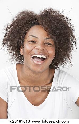 Stock Image - Portrait of a joyful African American young woman laughing against white background. Fotosearch