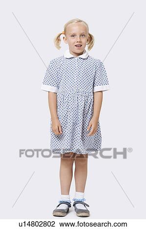 Stock Image - Portrait of a little girl standing over white background. Fotosearch