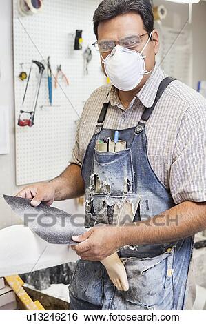 Portrait of a mature male worker polishing prosthetic limb in workshop View Large Photo Image Stock Photograph - Portrait of a mature male worker polishing prosthetic limb in workshop. Fotosearch