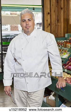 Stock Image - Portrait of a mid adult chef standing in market. Fotosearch