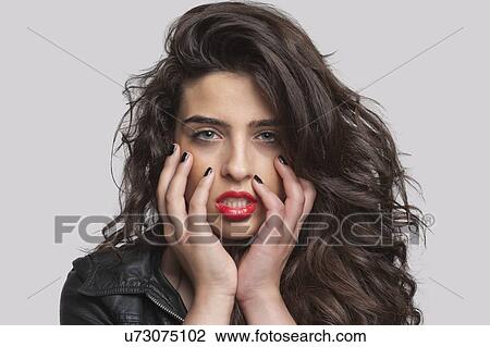 Stock Image - Portrait of a seductive young female over gray background. Fotosearch