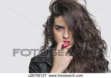 Stock Photo - Portrait of a sensuous young woman over gray background. Fotosearch