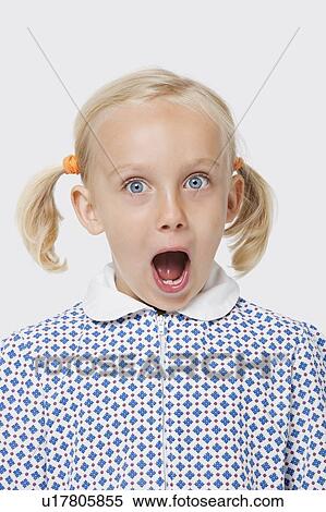 Stock Photography - Portrait of a surprised young girl with mouth open over white background. Fotosearch