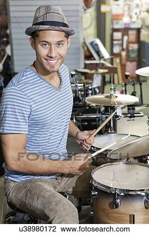 Portrait of a young man playing drums in music store View Large Photo Image Stock Image - Portrait of a young man playing drums in music store. Fotosearch