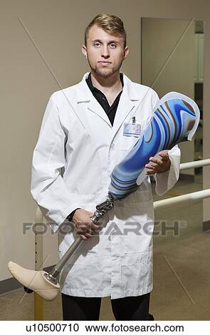 Stock Image - Portrait of a young technician with advanced prosthetic foot. Fotosearch