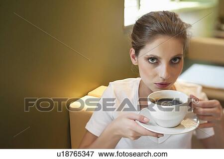 Stock Photo - Portrait of a young woman drinking coffee. Fotosearch
