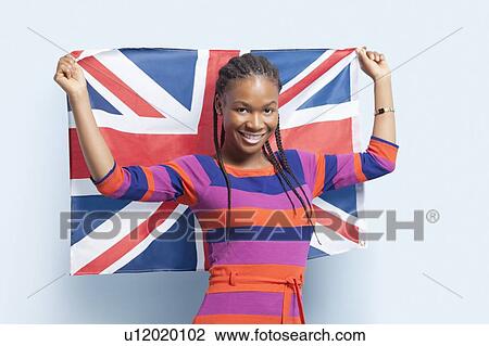 Portrait of a young woman with braided hair holding British flag over light blue background View Large Photo Image Stock Image - Portrait of a young woman with braided hair holding British flag over light blue background. Fotosearch
