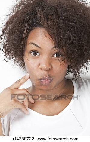 Stock Image - Portrait of African American young woman making funny faces. Fotosearch