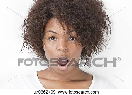 Stock Photo - Portrait of amazed young woman with mouth open against white background. Fotosearch