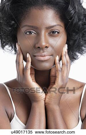 Stock Photography - Portrait of an African American young woman with hands on face. Fotosearch