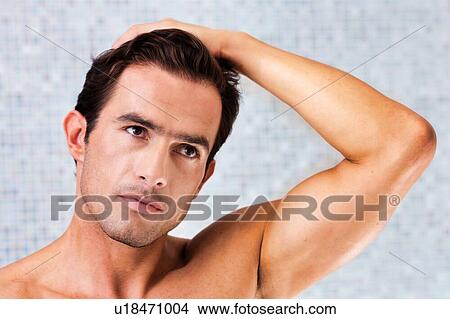 Picture - Portrait of attractive man checking his face in the mirror. Fotosearch