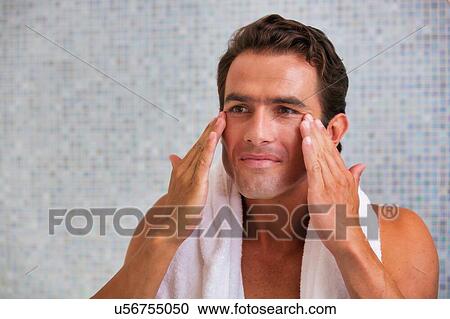 Portrait of attractive man cleansing his face with facial foam in the bathroom View Large Photo Image Stock Image - Portrait of attractive man cleansing his face with facial foam in the bathroom. Fotosearch