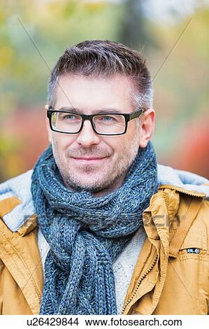 Picture - Portrait of attractive man standing in park. Fotosearch