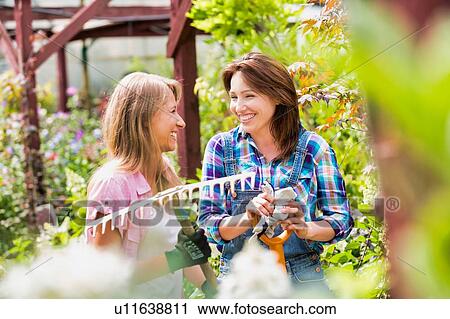 Stock Image - Portrait of beautiful gardeners walking while talking . Fotosearch
