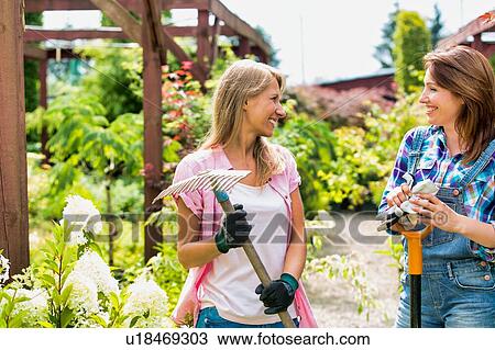 Portrait of beautiful gardeners walking while talking  View Large Photo Image Stock Image - Portrait of beautiful gardeners walking while talking . Fotosearch