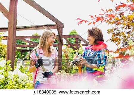 Stock Photography - Portrait of beautiful gardeners walking while talking . Fotosearch