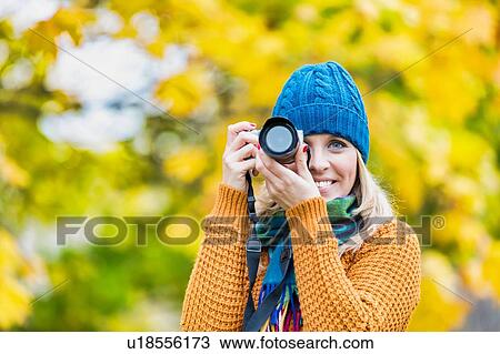 Portrait of beautiful woman photographing lovely maple trees in park View Large Photo Image Stock Image - Portrait of beautiful woman photographing lovely maple trees in park. Fotosearch