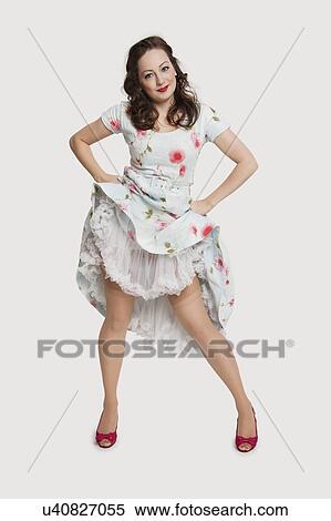 Portrait of beautiful young woman in dress with hands on hips against white background View Large Photo Image Stock Photography - Portrait of beautiful young woman in dress with hands on hips against white background. Fotosearch