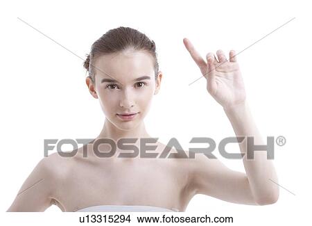 Portrait of beautiful young woman pointing up against white background View Large Photo Image Picture - Portrait of beautiful young woman pointing up against white background. Fotosearch