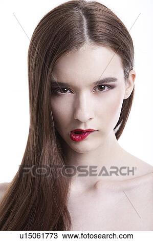 Portrait of beautiful young woman biting her lip against white background View Large Photo Image Stock Image - Portrait of beautiful young woman biting her lip against white background. Fotosearch