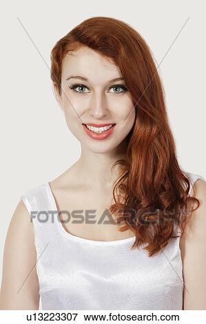 Portrait of beautiful young woman smiling against gray background View Large Photo Image Stock Photo - Portrait of beautiful young woman smiling against gray background. Fotosearch
