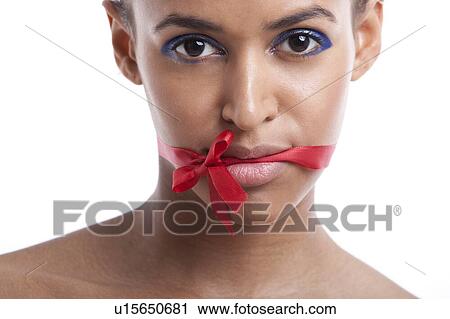 Portrait of beautiful young woman with ribbon tied over her mouth against white background View Large Photo Image Stock Image - Portrait of beautiful young woman with ribbon tied over her mouth against white background. Fotosearch