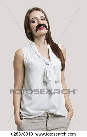 Portrait of beautiful young woman with fake mustache against gray background View Large Photo Image Stock Image - Portrait of beautiful young woman with fake mustache against gray background. Fotosearch
