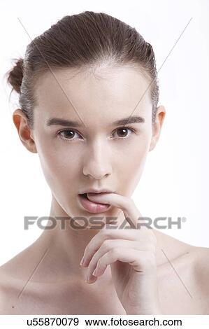 Portrait of beautiful young woman with finger in mouth against white background View Large Photo Image Stock Photo - Portrait of beautiful young woman with finger in mouth against white background. Fotosearch