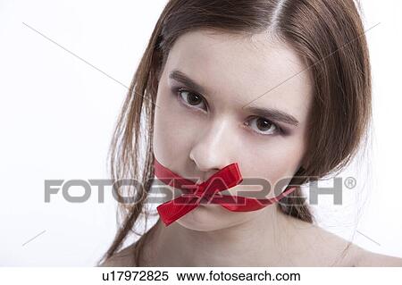 Portrait of beautiful young woman with red ribbon tied over mouth against white background View Large Photo Image Stock Photography - Portrait of beautiful young woman with red ribbon tied over mouth against white background. Fotosearch