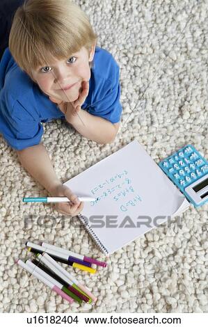 Portrait of blond hair boy lying on rug doing homework View Large Photo Image Picture - Portrait of blond hair boy lying on rug doing homework. Fotosearch