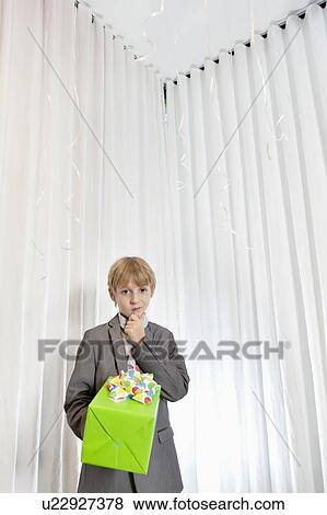 Portrait of boy with hand on chin giving gift View Large Photo Image Stock Photo - Portrait of boy with hand on chin giving gift. Fotosearch