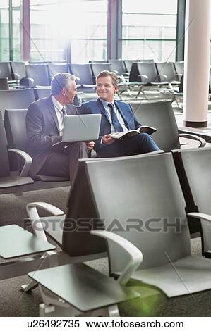 Portrait of business people sitting while waiting for boarding in airport View Large Photo Image Stock Photography - Portrait of business people sitting while waiting for boarding in airport. Fotosearch