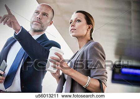 Portrait of businessman gesturing while talking to young attractive businesswoman in train station View Large Photo Image Stock Image - Portrait of businessman gesturing while talking to young attractive businesswoman in train station. Fotosearch