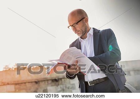Portrait of businessman reading documents View Large Photo Image Stock Photography - Portrait of businessman reading documents. Fotosearch