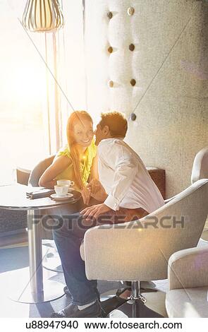 Portrait of Businessman sitting and whispering to his girlfriend in coffee shop View Large Photo Image Stock Image - Portrait of Businessman sitting and whispering to his girlfriend in coffee shop. Fotosearch