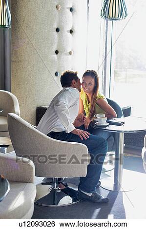 Portrait of Businessman sitting and whispering to his girlfriend in coffee shop View Large Photo Image Stock Photograph - Portrait of Businessman sitting and whispering to his girlfriend in coffee shop. Fotosearch