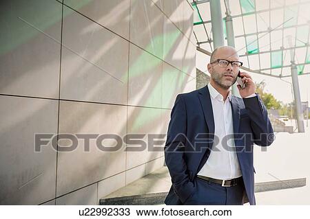 Stock Image - Portrait of businessman talking on smartphone. Fotosearch